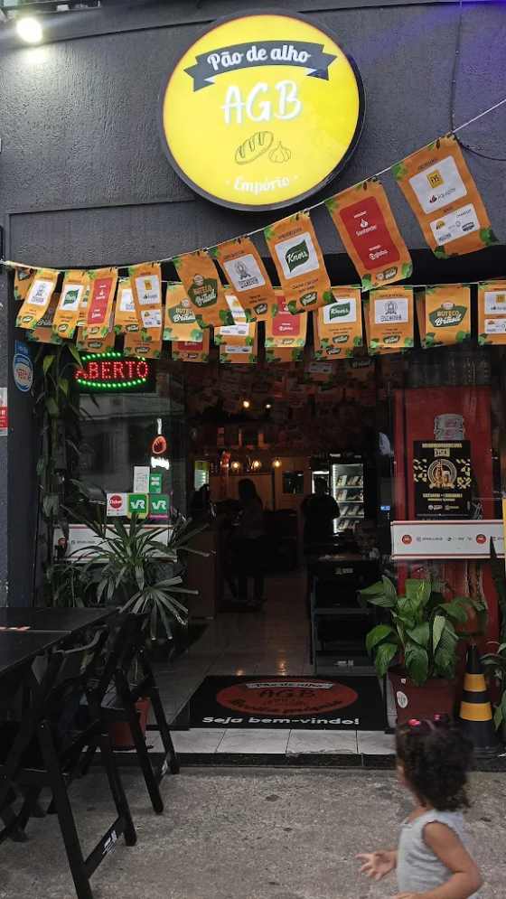 Fachada do Empório Pão de Alho AGB iluminada à noite, no Ipiranga
