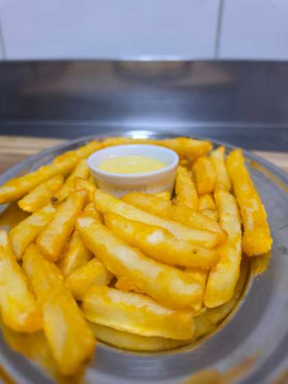 Porção de batata frita crocante com molho da casa